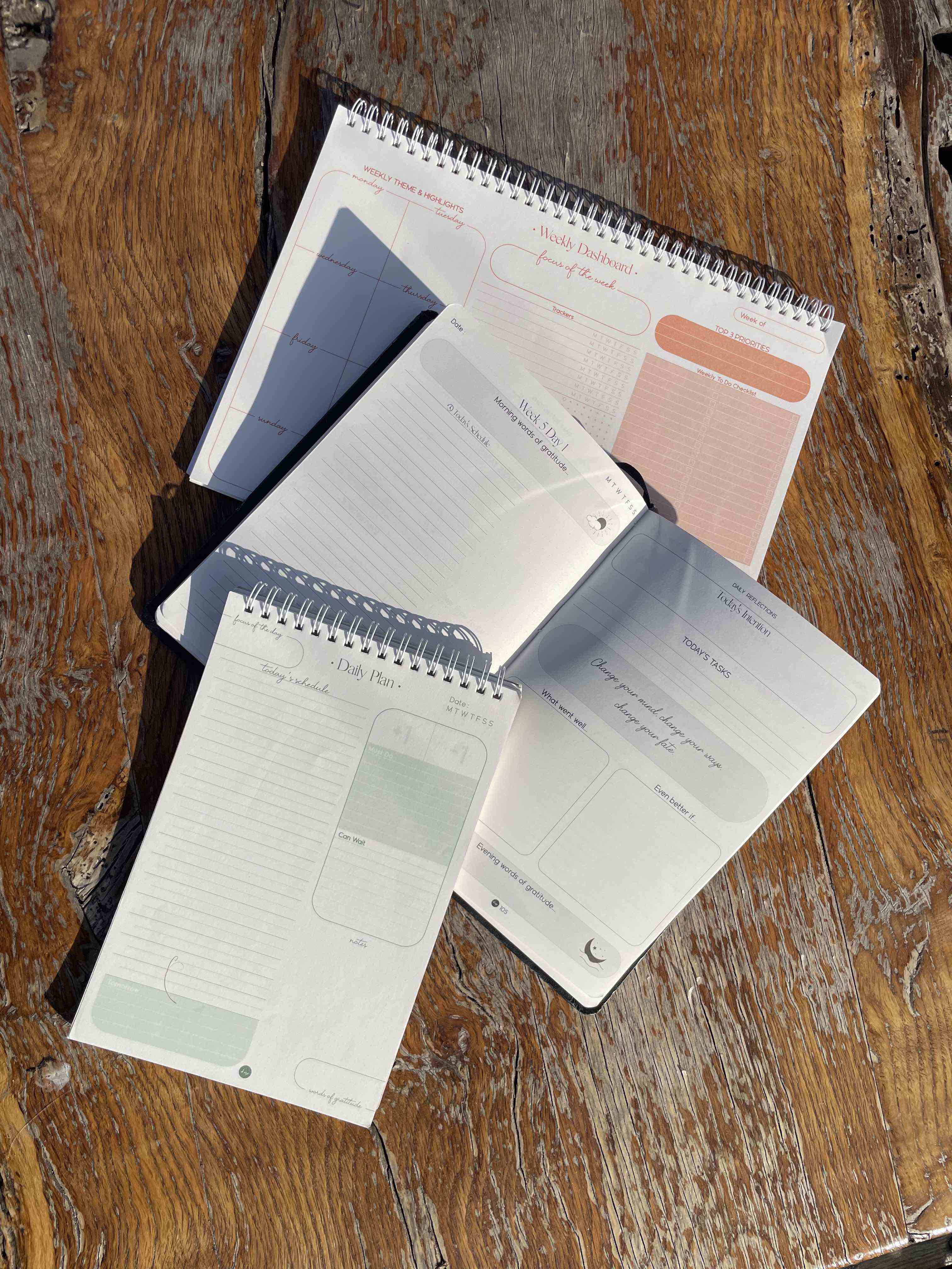 thoughtfully designed notebooks and planners on a wooden surface